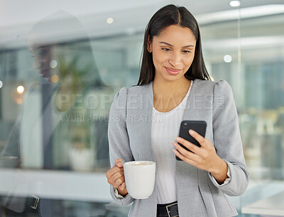 Buy stock photo Shot of a young businesswoman using a smartphone and having coffee in a modern office