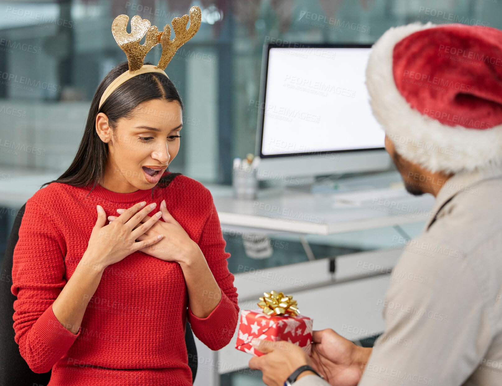 Buy stock photo Shot of a young businessman and businesswoman exchanging Christmas gifts in a modern office