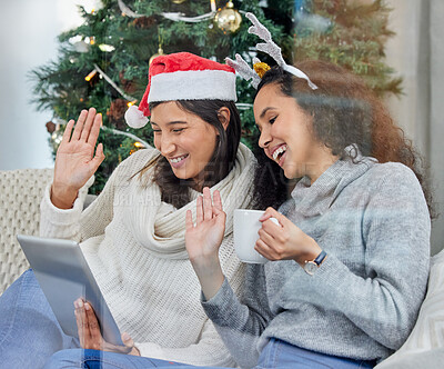 Buy stock photo Women, friends and video call or Christmas wave in home for festive season hello, holiday or connection. Female people, tree and hot chocolate on sofa with tablet for winter break, bonding or virtual