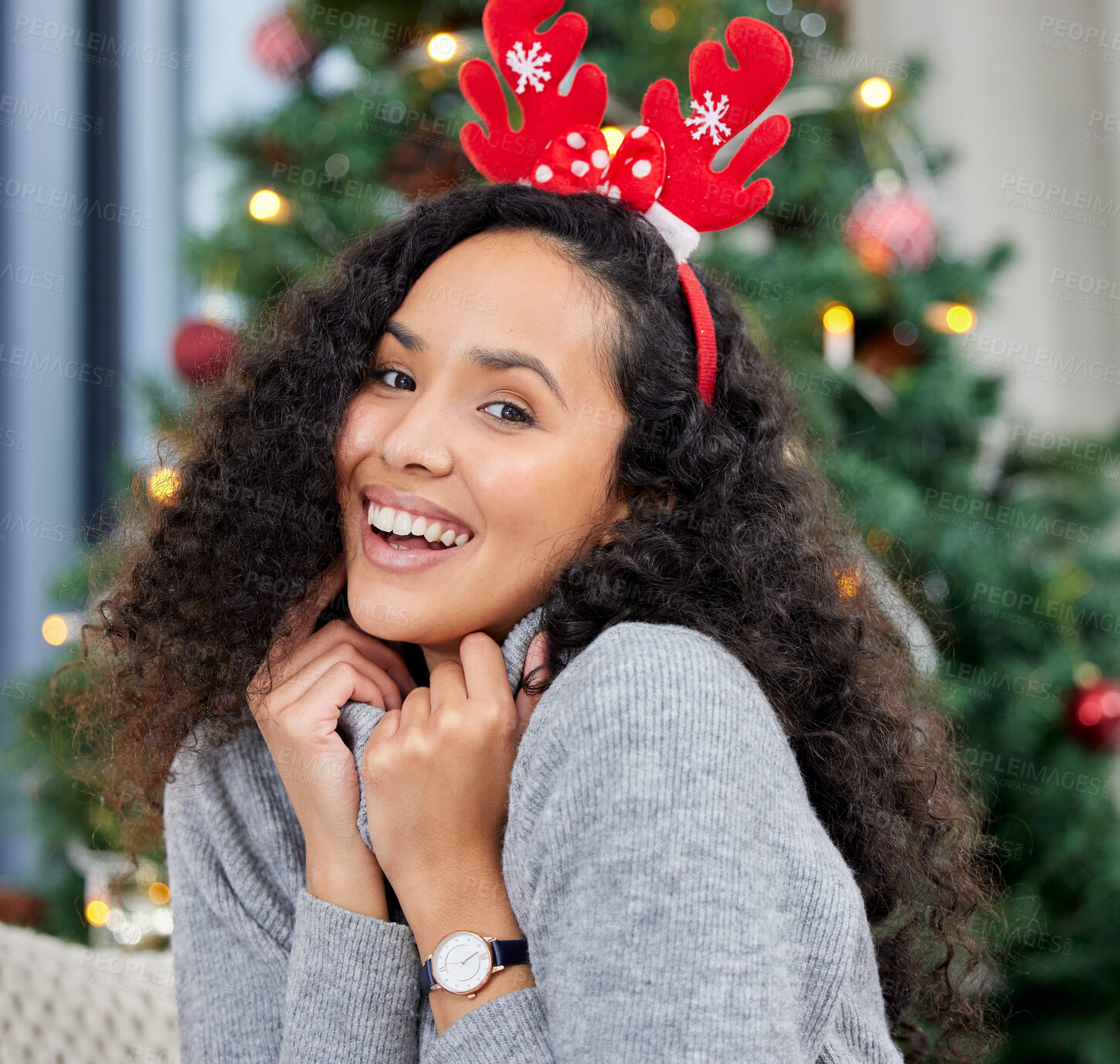 Buy stock photo Shot of a young woman celebrating Christmas at home