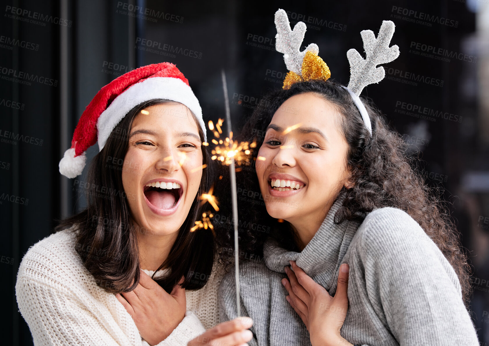 Buy stock photo Women friends, Christmas and sparkle light with smile, home and celebration of festive holiday. Girl, woman and excited with fireworks, celebrate and happiness on vacation, laughing and xmas bonding