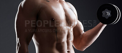 Buy stock photo Shot of an athletic man lifting dumbbells against a dark background