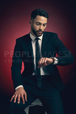Buy stock photo Studio shot of a young man posing against a red background