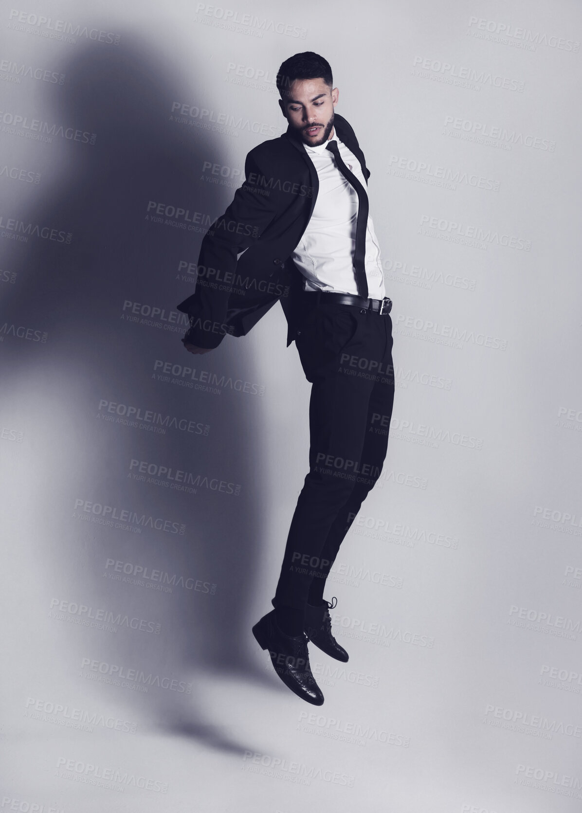 Buy stock photo Studio shot of a young man jumping against a grey background