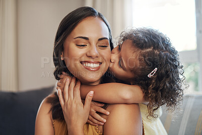 Buy stock photo Shot of an adorable young girl hugging and kissing her mother in the living room at home