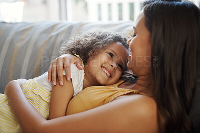 Buy stock photo Shot of an adorable young girl lying down with her mother on the sofa at home