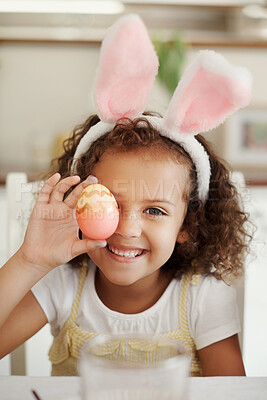 Buy stock photo Shot of a little girl covering her eye with a painted Easter egg