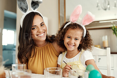 Buy stock photo Shot of a mother painting easter eggs with her daughter