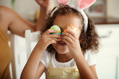 Buy stock photo Shot of a little girl covering her eye with a painted Easter egg