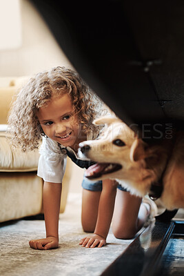 Buy stock photo Shot of an adorable young girl playing with her dog in the living room at home