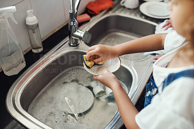 Buy stock photo Cropped shot of an unrecognizable girl standing and washing the dishes in the kitchen sink at home