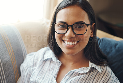 Buy stock photo Cropped portrait of an attractive young woman chilling on the sofa at home