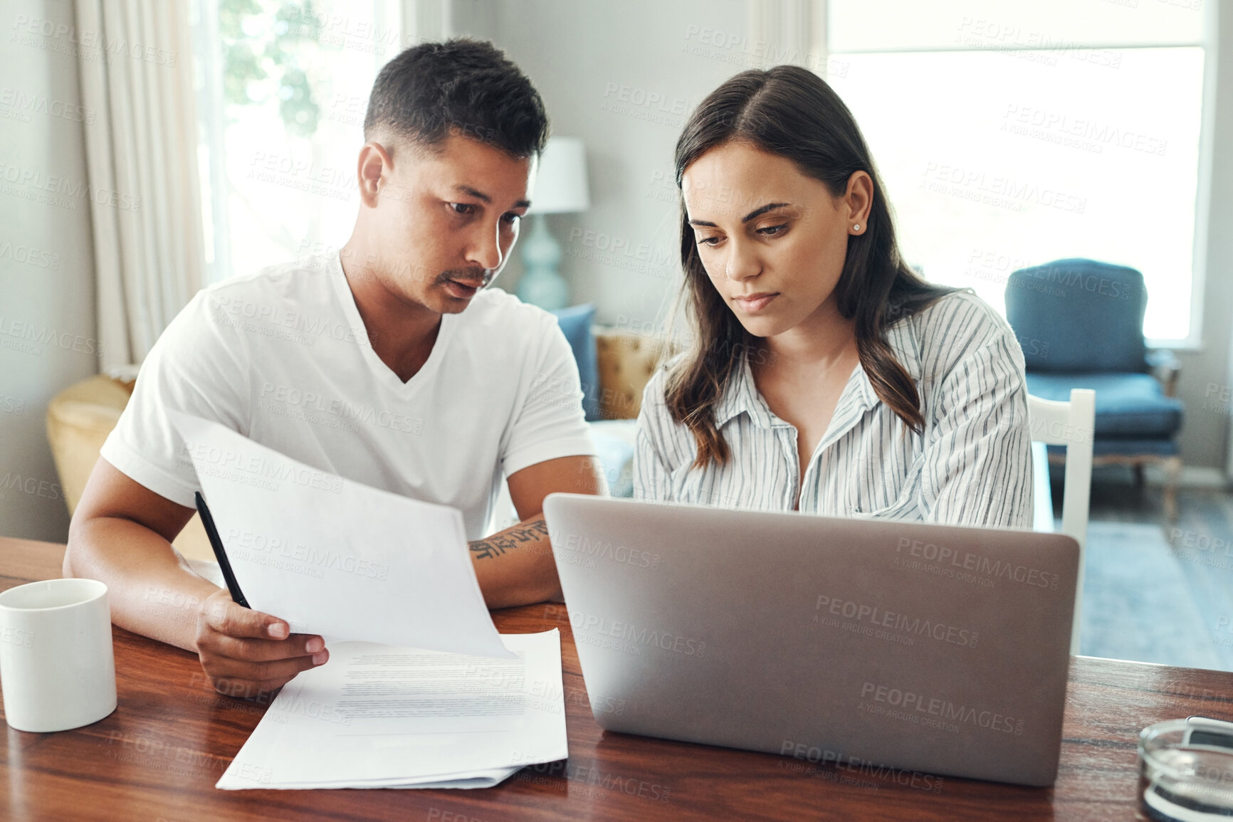 Buy stock photo Cropped shot of a young couple using a laptop to their household budget in the living room at home