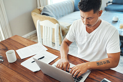 Buy stock photo Cropped shot of a handsome young man working on his laptop in the living room at home