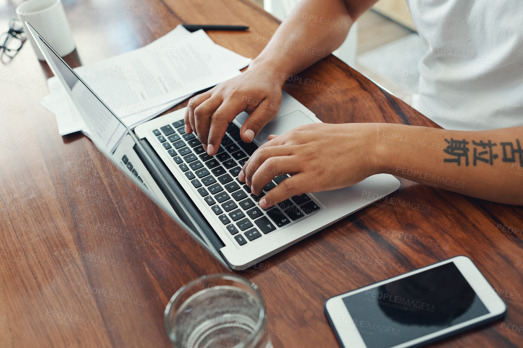 Buy stock photo Cropped shot of an unrecognizable man working on his laptop in the living room at home