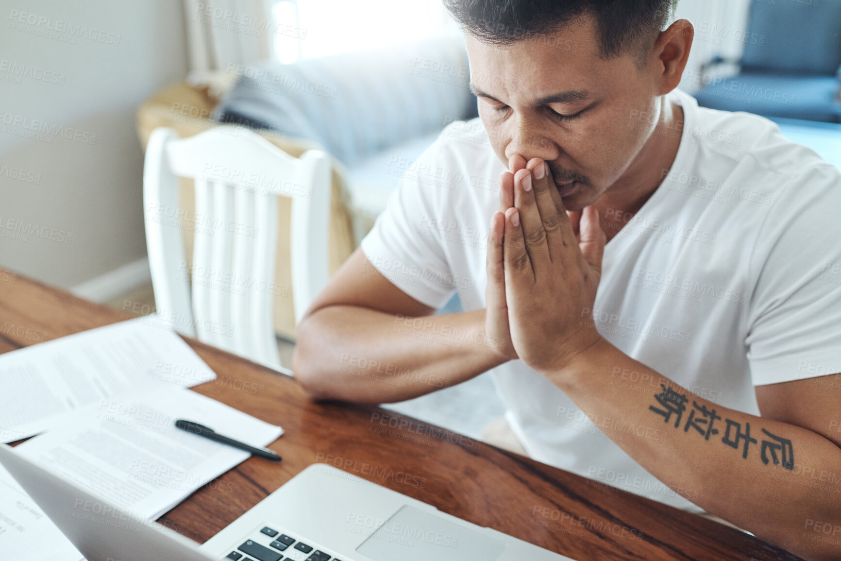 Buy stock photo Cropped shot of a handsome young man looking stressed while working on a laptop in the living room at home