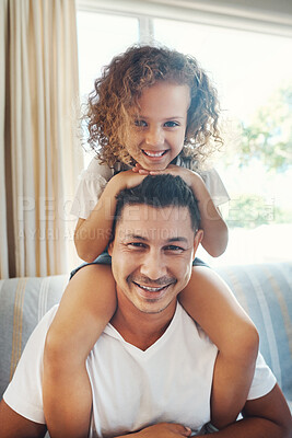 Buy stock photo Shot of a handsome young man carrying his daughter on his shoulders in the living room at home