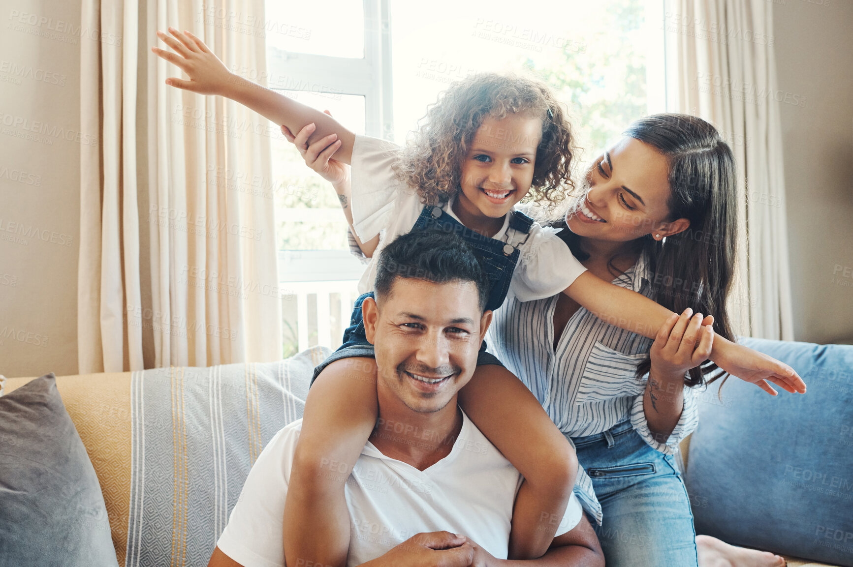 Buy stock photo Sofa, parents and child on shoulders in portrait for bonding, support and kids development in family home. Mom, dad and girl on couch with playful fun, smile and love for happy people in living room