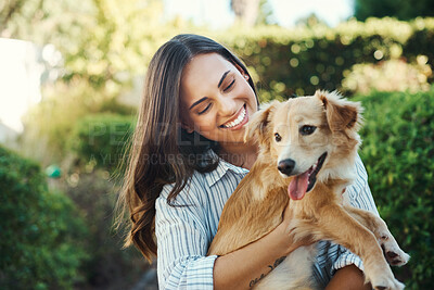 Buy stock photo Shot of a young woman cuddling her dog