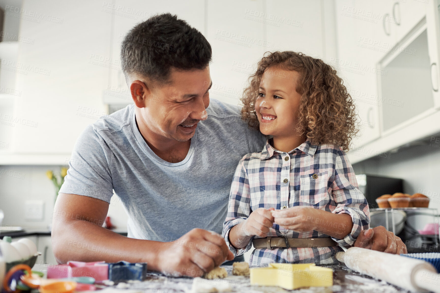 Buy stock photo Shot of a sweet little girl baking with her father at home in the kitchen