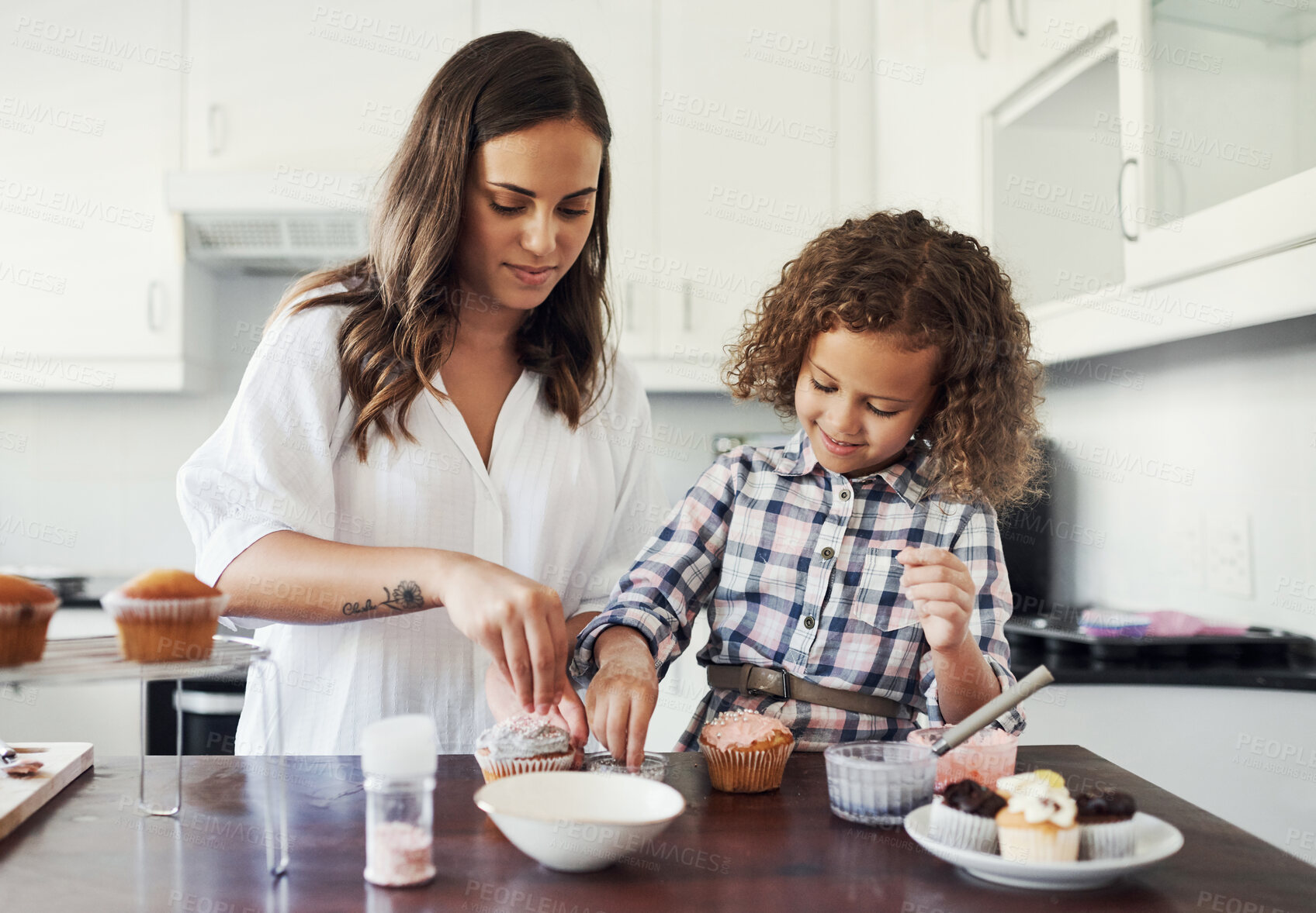 Buy stock photo Mom, kid and decorating of cupcake in kitchen on counter for baking, support and learning of recipe. Happy, woman and daughter with sweet dessert for teaching, creativity and love together at home