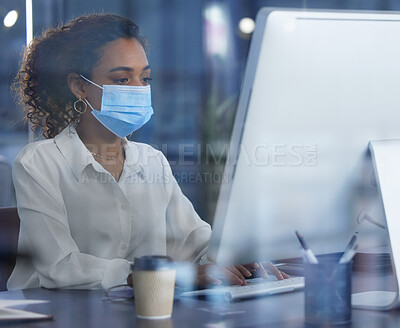 Buy stock photo Shot of a young businesswoman wearing a mask while working in an office at work