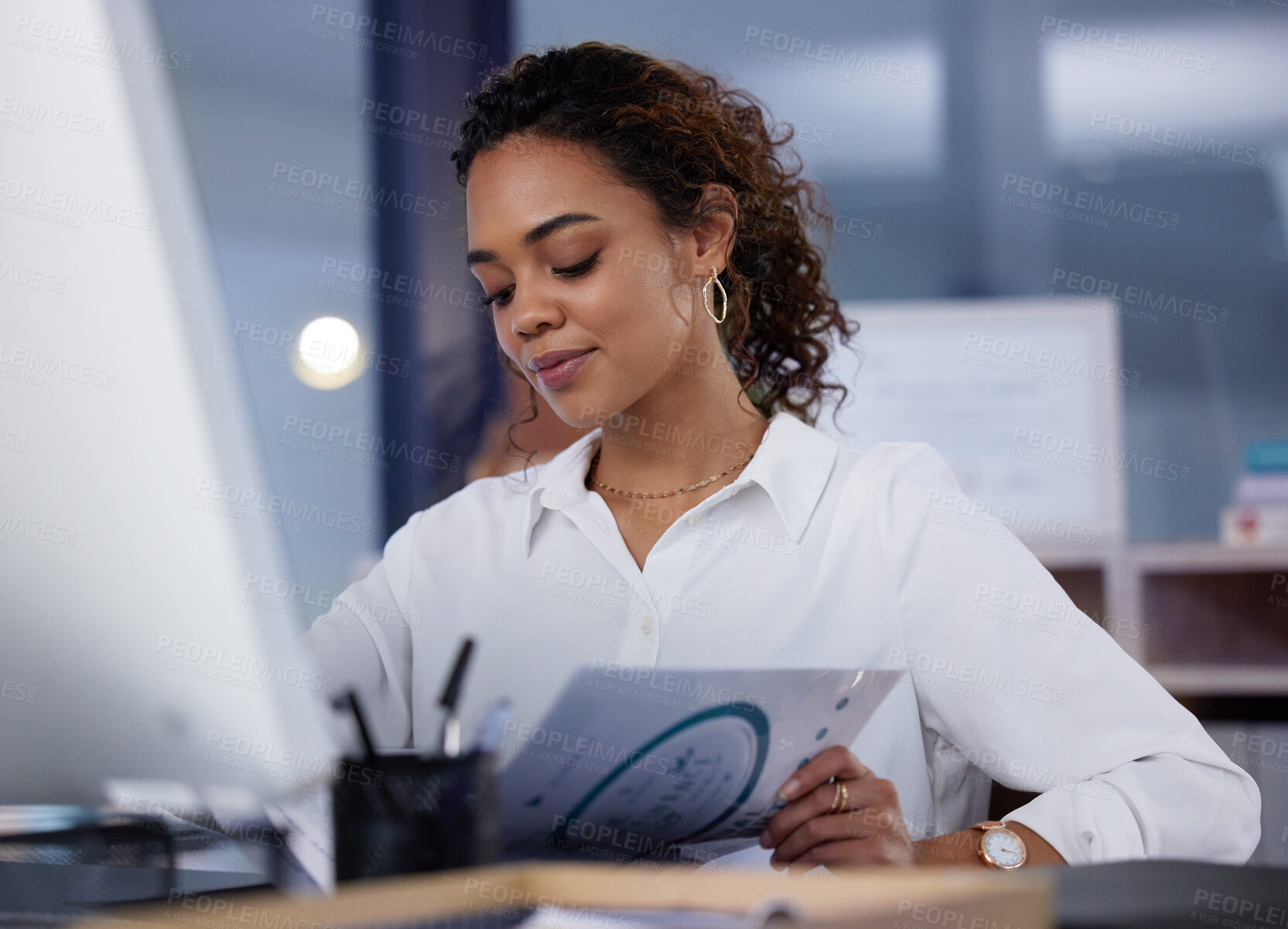 Buy stock photo Shot of a young businesswoman going through paperwork in an office at work