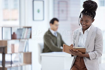 Buy stock photo Shot of a young businesswoman wearing a headset and writing notes while working in an office