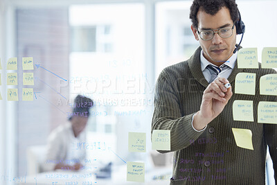 Buy stock photo Office, man and glass board at call center for strategy, planning and sticky notes for customer support and service. Office, crm and microphone as consultant with vision, ideas for company growth