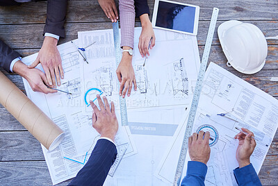 Buy stock photo High angle shot of a diverse group of businesspeople huddled around building plans