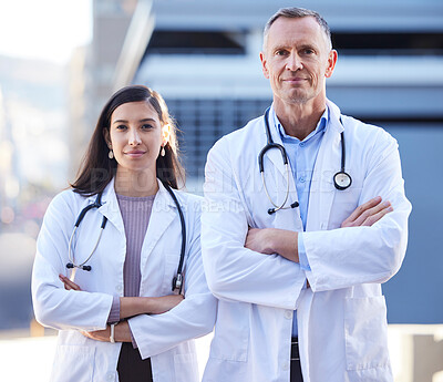 Buy stock photo Portrait of two doctors with folded arms outside in the city