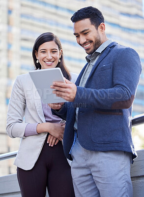 Buy stock photo Shot of two coworkers using a digital tablet together