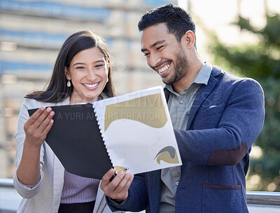 Buy stock photo Shot of two businesspeople reviewing documents together