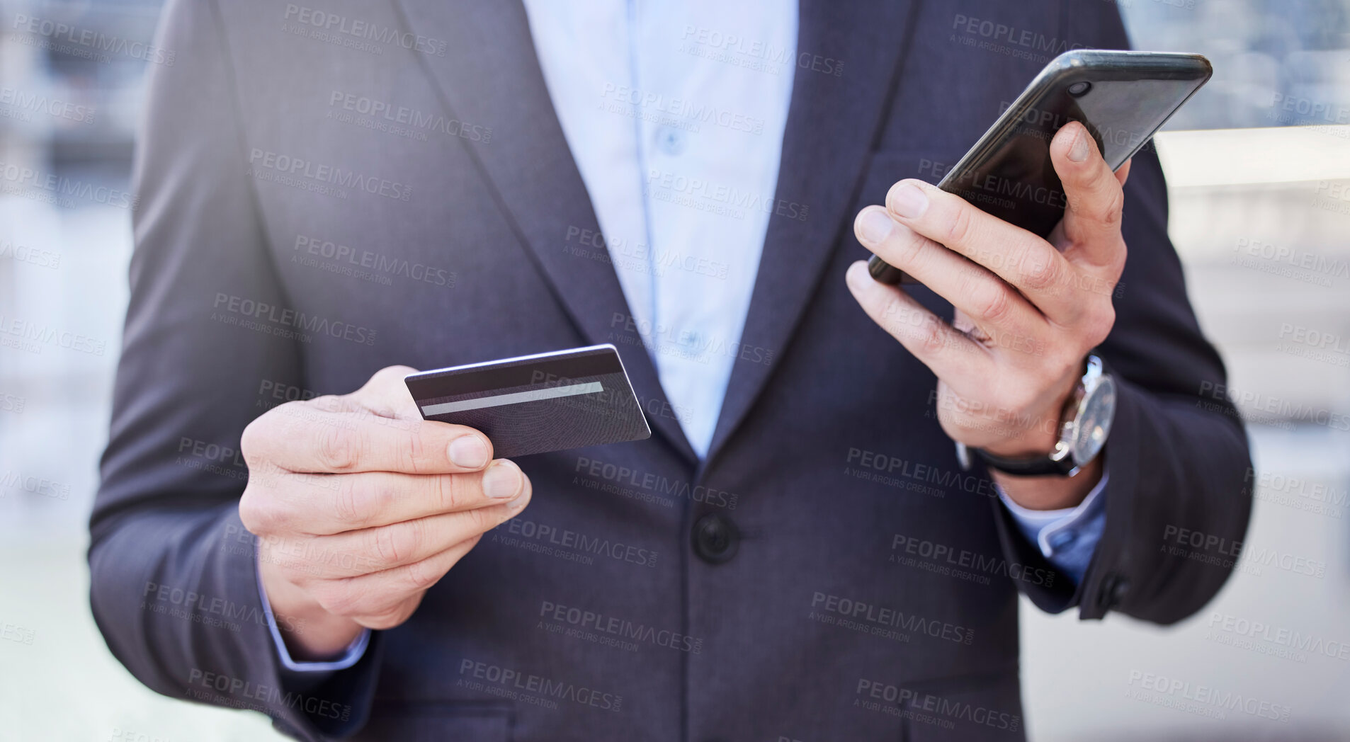Buy stock photo Shot of a unrecognizable business man shopping on line using his phone outside