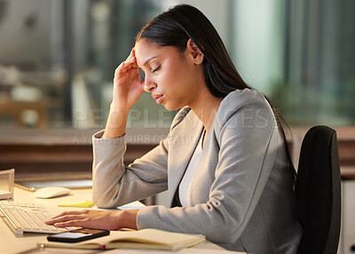 Buy stock photo Shot of a young businesswoman looking stressed while using a computer at her desk in a modern office