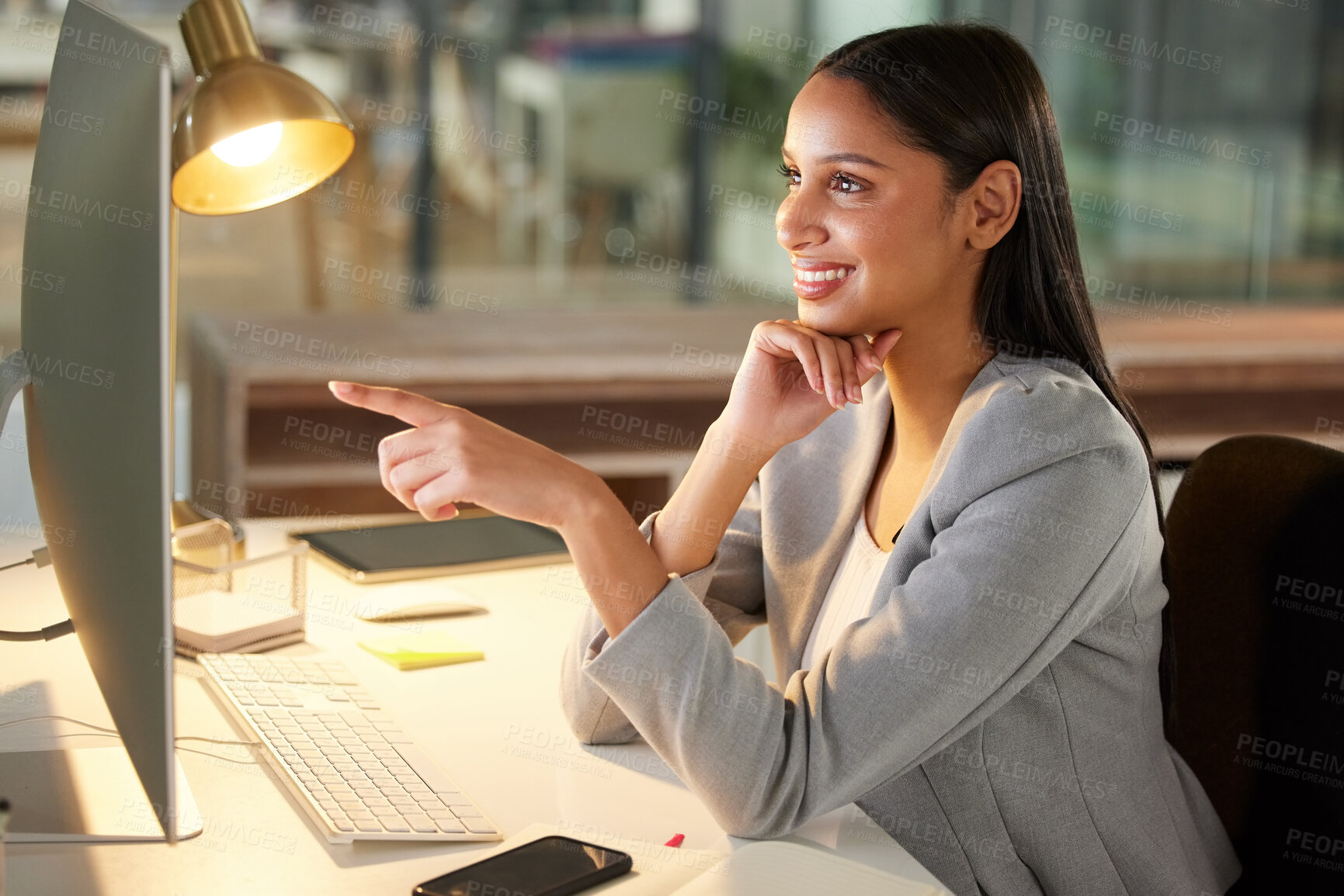 Buy stock photo Shot of a young businesswoman using a computer in a modern office