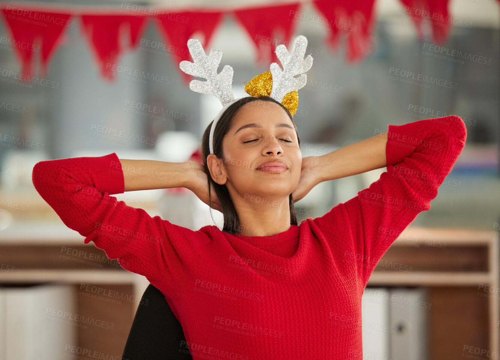 Buy stock photo Shot of a young businesswoman relaxing at her desk in a modern office at Christmas