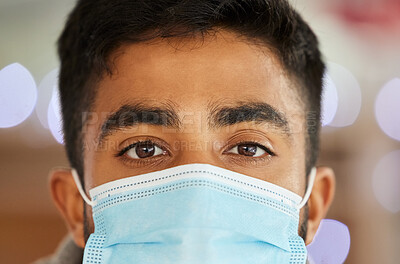 Buy stock photo Portrait of a young man wearing a surgical face mask indoors