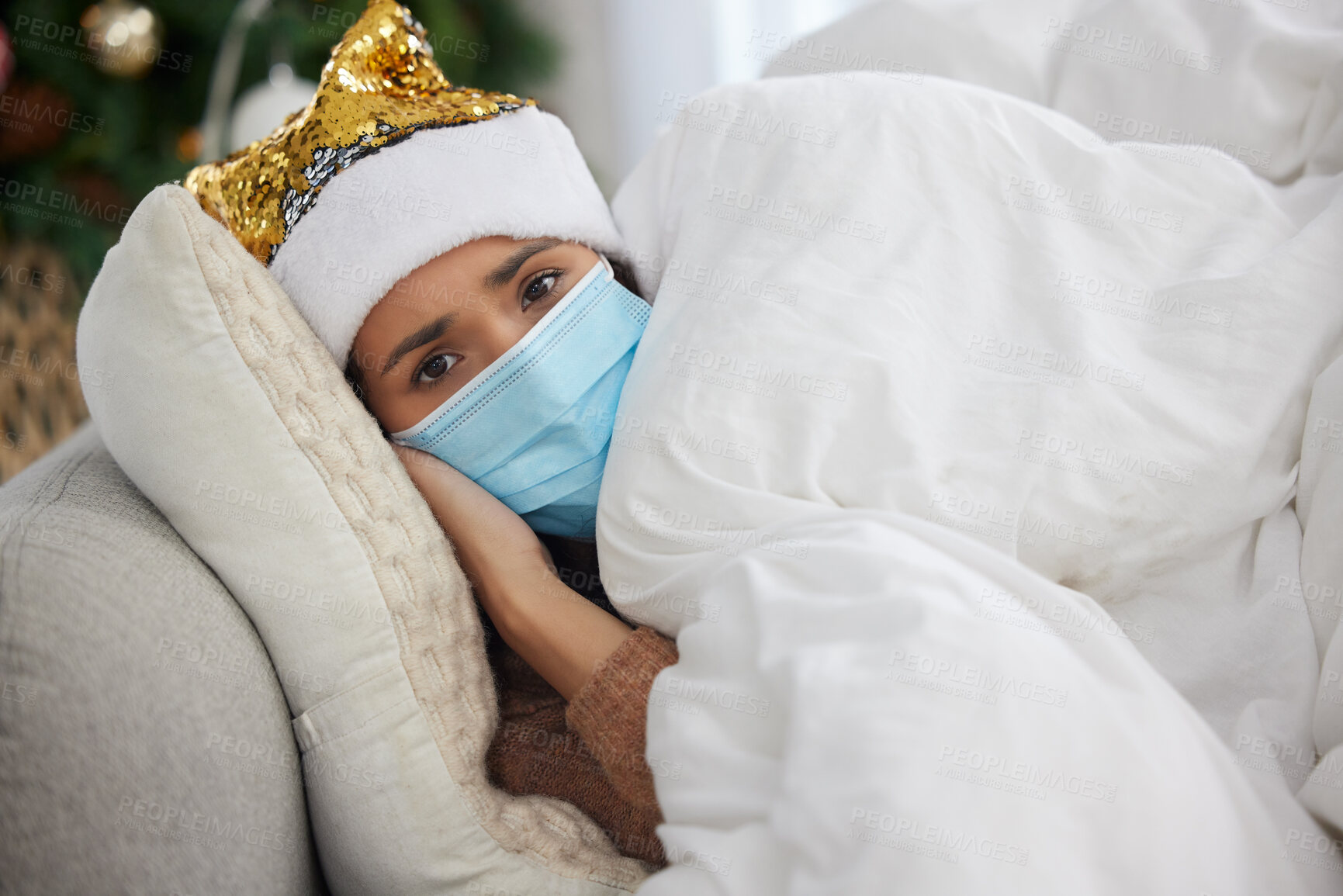 Buy stock photo Person, portrait and sick at home on Christmas holiday on sofa with face mask or hat, virus or infection. Woman, tired and couch with blanket for fever or festive season vacation, winter or unhappy