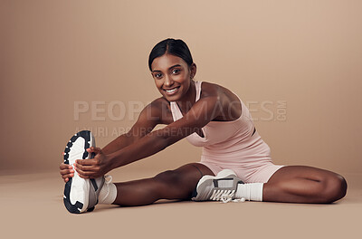 Buy stock photo Full length shot of an attractive young woman sitting alone in the studio and stretching before working out
