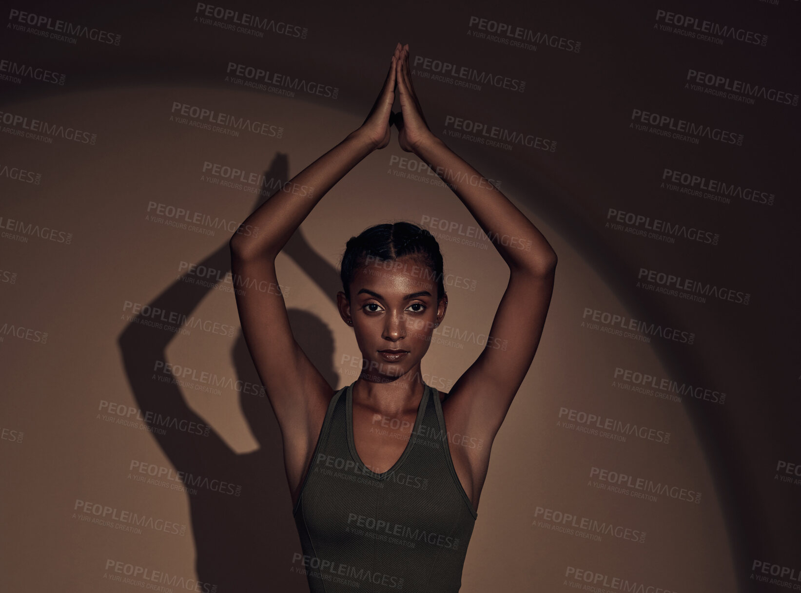 Buy stock photo Shot of an attractive young woman standing alone in the studio and holding a meditative pose while practising yoga