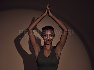 Buy stock photo Shot of an attractive young woman standing alone in the studio and holding a meditative pose while practising yoga