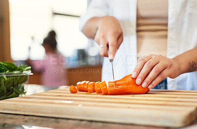 Buy stock photo Cropped shot of a woman chopping carrots at home