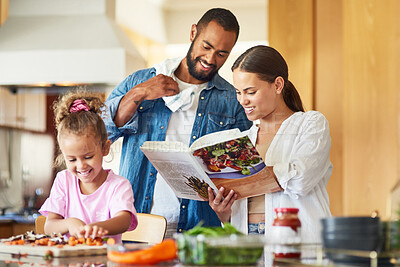 Buy stock photo Shot of a couple and their daughter cooking together in the kitchen at home