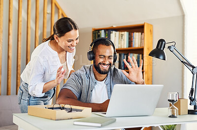 Buy stock photo Shot of a young couple waving during a video conference