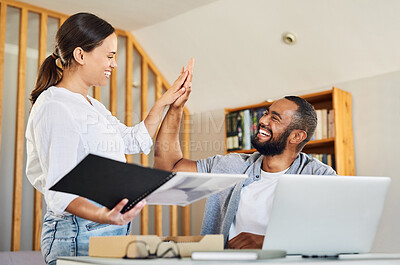 Buy stock photo Shot of a young couple high fiving after reviewing documents