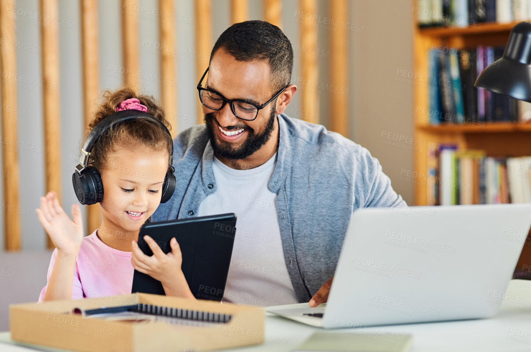 Buy stock photo Shot of a little girl using her fathers digital tablet to make a video call