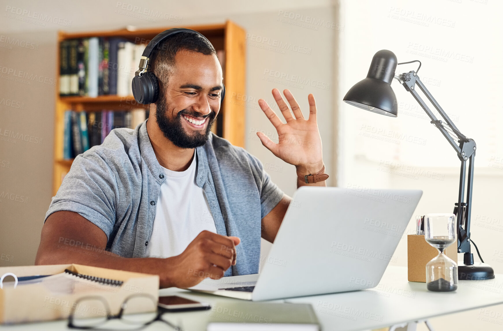 Buy stock photo Shot of a young businessman waving during a video meeting