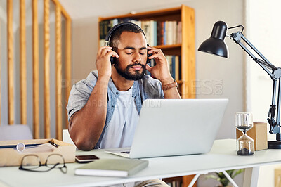 Buy stock photo Shot of a young businessman wearing headphones to listen to music