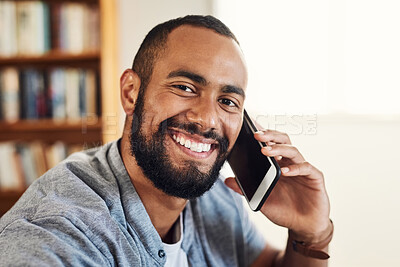 Buy stock photo Shot of a handsome businessman using his smartphone to make a phonecall while working from home